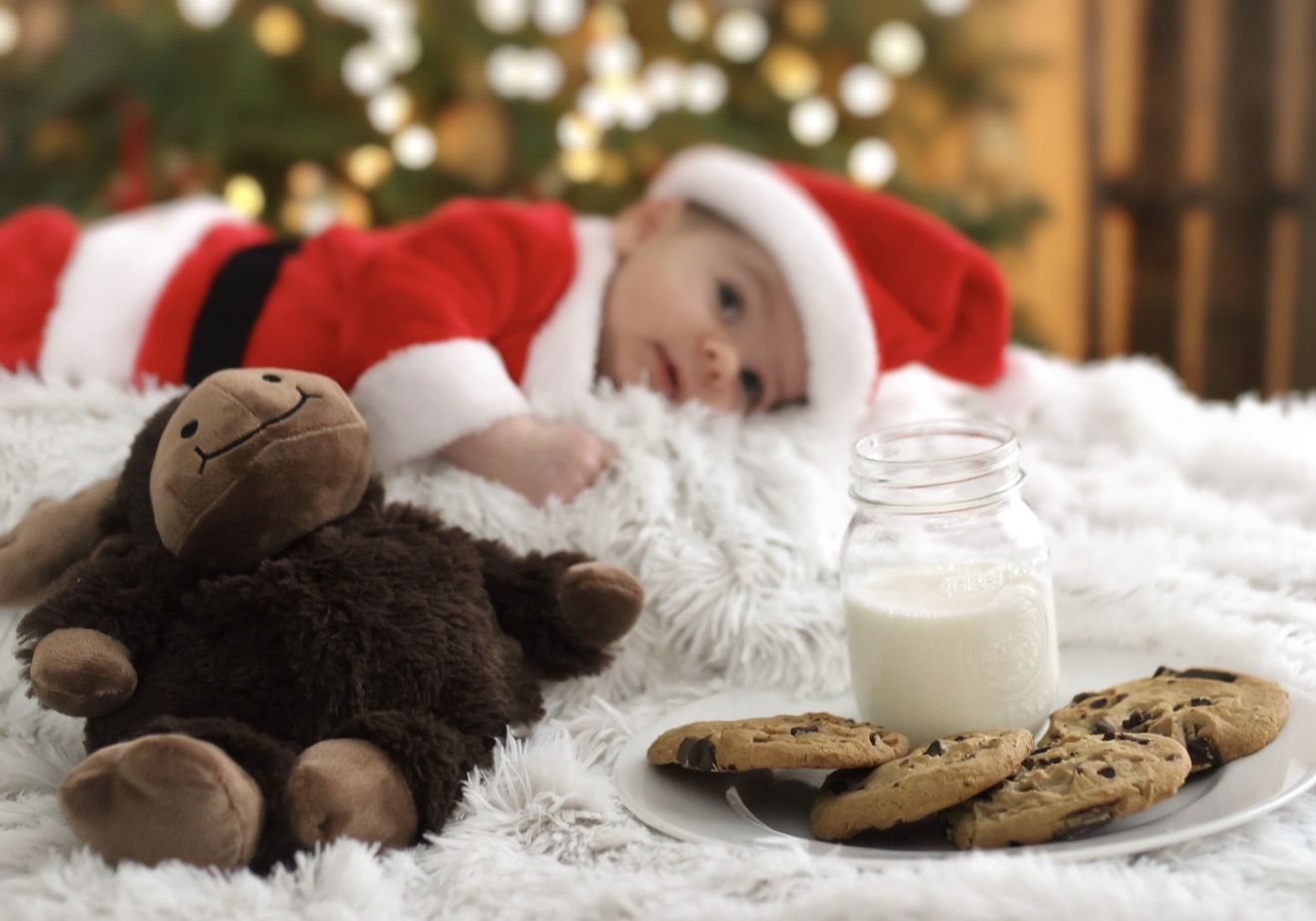 Baby in a Christmas portrait with cookies and milk