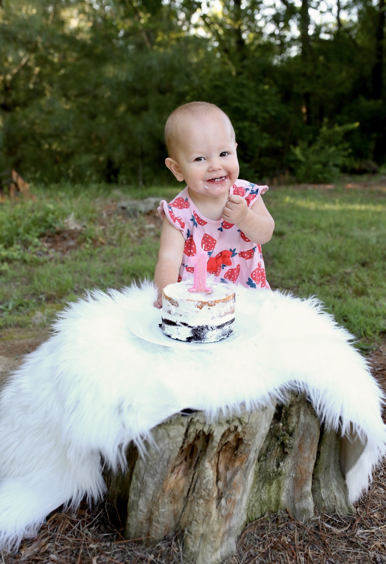 Baby seated on a soft white blanket outdoors